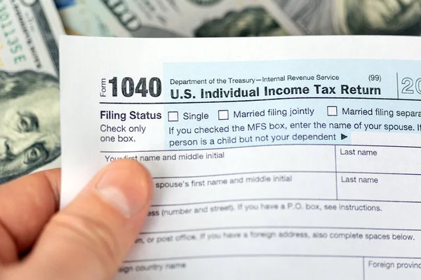 Uomo mano che detiene Stati Uniti reddito individuale 1040 forma fiscale — Foto Stock