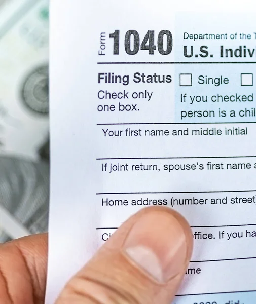 Homem mão segurando EUA renda individual 1040 forma de imposto — Fotografia de Stock