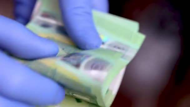 Handen met blauwe beschermende medische handschoenen tellen 100 EURO bankbiljetten — Stockvideo