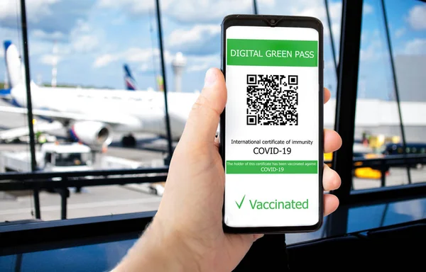 De digitale groene pas met de QR-code op het scherm van een mobiele telefoon in een mannenhand — Stockfoto