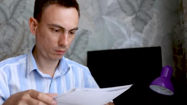 新聞の請求書を机の上に座っている不満を持つ男。破産概念 — ストック動画