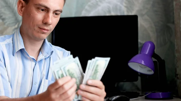 Udany młody człowiek liczący pieniądze ze szczęśliwymi emocjami. — Zdjęcie stockowe