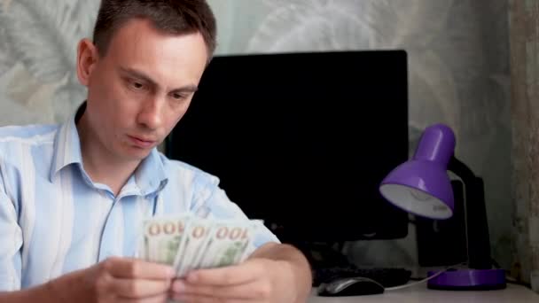 Młody człowiek z smutną twarzą liczy pieniądze w gotówce. — Wideo stockowe