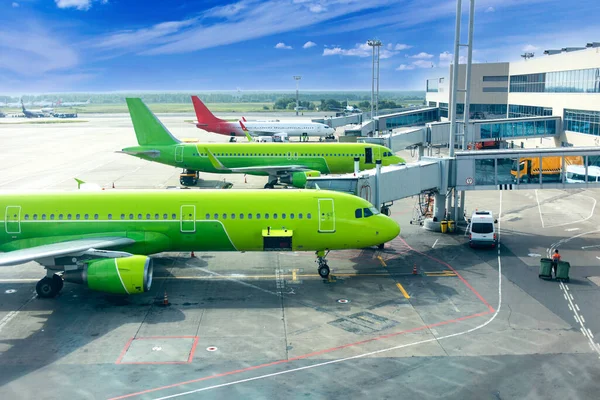 Passenger planes at airport near boarding terminal — Stock Photo, Image