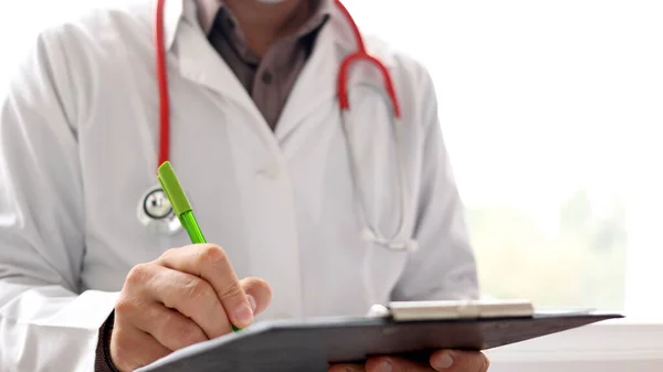 Médico escrevendo notas de paciente em um exame médico ou prescrição. — Fotografia de Stock