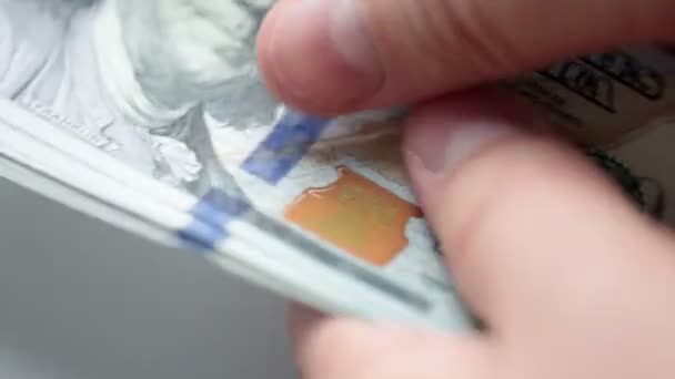 Видео, на котором человек считает свои деньги крупным планом. Новые банкноты номиналом 100 долларов США образца 2009 года были использованы в этом видео — стоковое видео