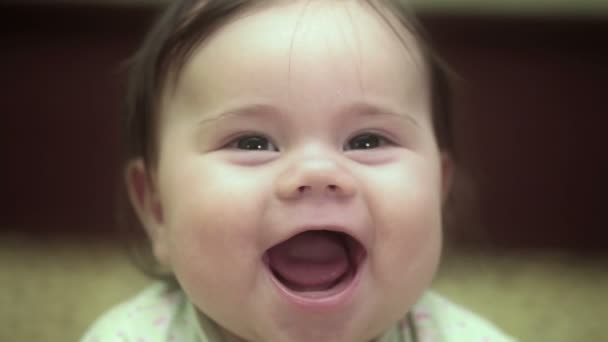 La petite fille de 5 mois sourit. Elle est allongée sur le canapé. Vidéo Full HD — Video