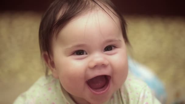 Pequena menina de 5 meses está sorrindo. Ela está deitada no sofá. FullHD vídeo — Vídeo de Stock