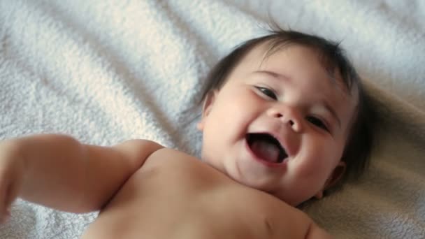 Pequena menina de 5 meses está sorrindo. Ela está deitada no sofá. FullHD vídeo — Vídeo de Stock