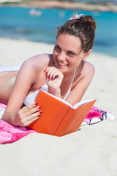 Mulher está lendo um livro em uma praia — Fotografia de Stock