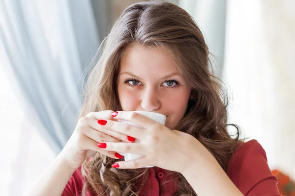 A woman in a restaurant is drinking coffee — Stock Photo, Image