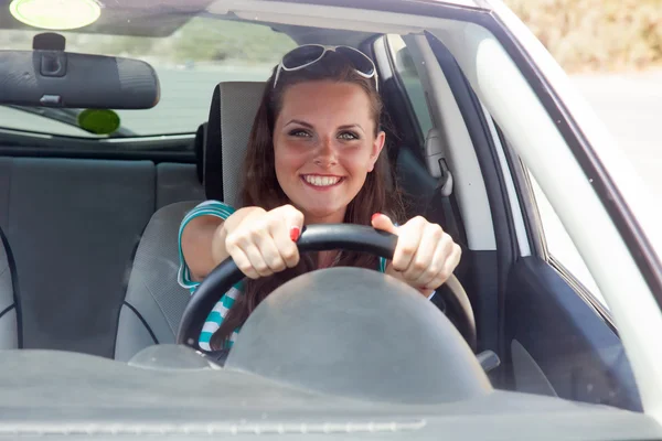 Mulher feliz está dirigindo um carro — Fotografia de Stock