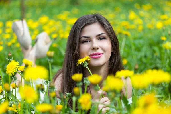 Mladá žena leží na poli — Stock fotografie