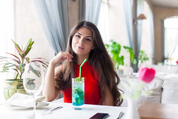 A woman in a restaurant is drinking cocktail — Stock Photo, Image