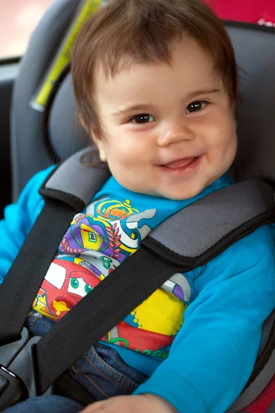 Linda niña está sentada en su asiento de seguridad del coche — Foto de Stock