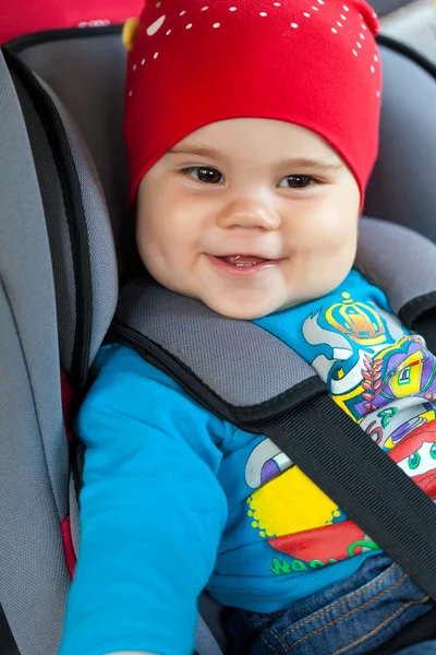 Cute little girl is sitting in her car safety seat — Stock Photo, Image