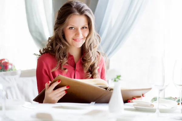 Una donna in un ristorante con il menu in mano — Foto Stock