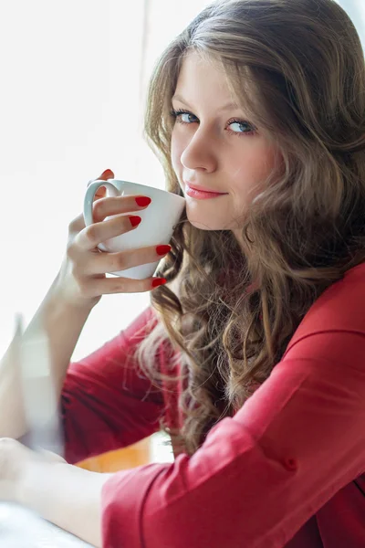 A woman in a restaurant is drinking coffee — Stock Photo, Image