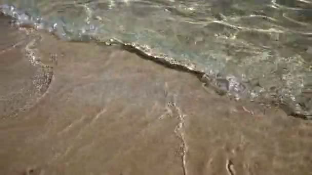 Sea water washes up a sandy shore and out again — Stock Video