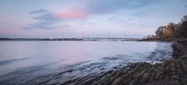 Panorama över en kust i havsviken med stenar vid solnedgången — Stockfoto