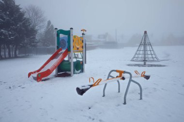 Boş kış oyun parkı karla kaplı.