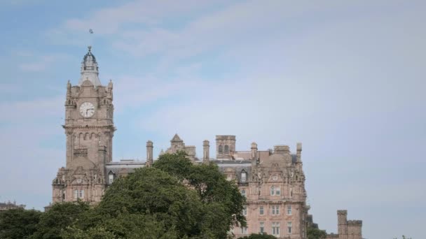 Egy régi épület toronnyal és órával Edinburgh-ban és repülő sirályokkal. — Stock videók