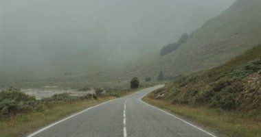 İskoçya 'da bir yol Sis kaplı bir gölün kıyıları boyunca