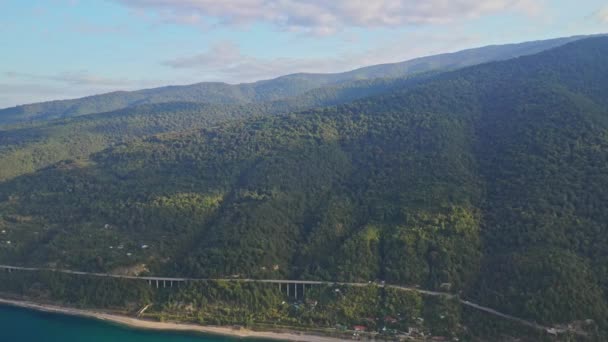 Berghänge mit Wald bedeckt, Autobahn, Meer von oben — Stockvideo