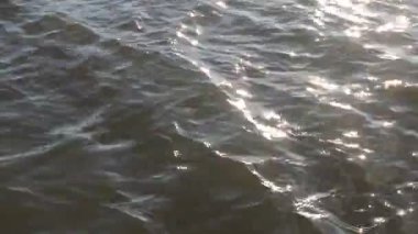 Işıldayan güneşin, akan su yüzeyine yansımasını kapat.