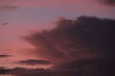 Dramatik günbatımında arka planda koyu mavi gökyüzü bulutları.