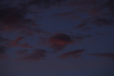 Karanlık akşam gökyüzü arkaplanı karamsar mor bulutlarla.