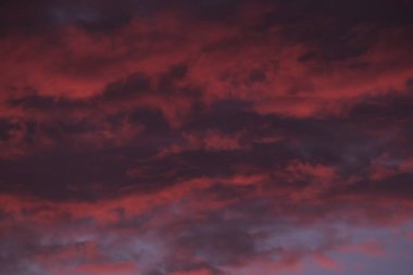 Ateşli kırmızı fırtına bulutları karanlık gökyüzü arka planında hareket ediyor