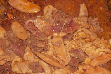 Kızarmış et ve sosislerin leziz yakın çekimi sıcak ızgarada baharatlı sosun içinde hararetle pişiyor..