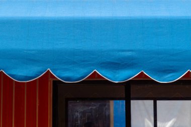 Kırmızı bir ön cephe üzerinde deniz tarağı kenarlı canlı mavi tente