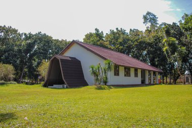Beyaz modern bina yeşil çimlerin üzerinde güneşli bir günde duruyor..