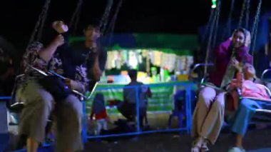 LOMBOK, İNDONEZYA - 15 Nisan 2025 - Düşük Işık Hareketi Çekimi Heyecan Veren Atlıkarınca Gezisi Gece Fuarında Parlak Işıklar Altında