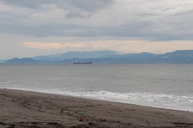 Okyanusta, sahilde ve dağlarda bir gemi.