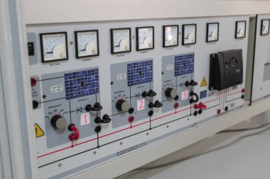 Elektrik mühendisliği çalışmaları ve yenilenebilir teknoloji eğitimi için kullanılan çoklu ölçüm göstergelerini, şalterleri, kabloları ve modül kontrollerini gösteren modern güneş enerjisi eğitim aparatları ayrıntılı görünümü.