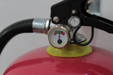 Sıfır çubuğu gösteren kırmızı taşınabilir yangın söndürme göstergesi, düşük basıncı ve acil bakım ve şarj hizmetinin gerekliliğini simgeleyen ayrıntılı bir çekim..