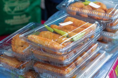 Tek kullanımlık plastik kutularda kızartılmış Endonezya atıştırmalıkları.