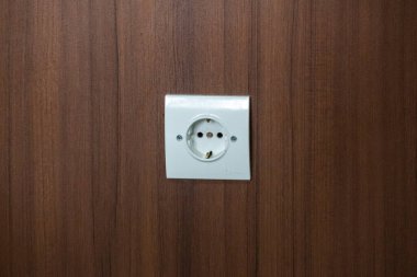 Enerji ve ev teknolojisi kavramları için ideal, ev elektrik sistemi ve ev elektrik erişimi gösteren ahşap paneller üzerindeki elektrik prizi