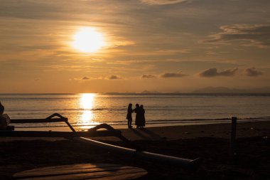 Tropikal sahillerdeki siluet gibi büyüleyici günbatımı ve altın saat ışığı seyahat noktalarını ve huzurlu tatilleri temsil ediyor.