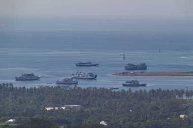 Huzurlu sularda yüzen feribotların yer aldığı pitoresk tropikal manzara, HDR 'de reklam için uygun bol miktarda kopya alanı sunuluyor.