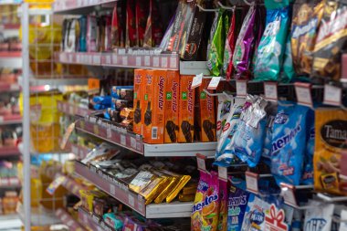 18 Eylül 2025 'te Mataram, Endonezya' daki bir mağazada farklı marka abur cubur ve şekerler