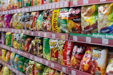 18 Eylül 2025 'te Mataram, Endonezya' da bir mağaza rafında farklı patates cipsi markaları düzenlendi.