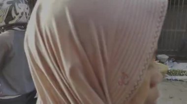 19 Şubat 2025, Mataram, Endonezya 'da market tezgahları arasında motosiklet kullanan yolcular