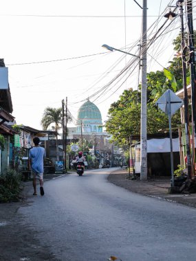 6 Haziran 2025 'te Lombok, Endonezya' da yol ve cami yakınlarında yürüyen yerel halk