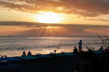 Mataram, Endonezya kıyılarında, gün batımında insanlarla dolu bir deniz manzarası, 14 Ağustos 2025
