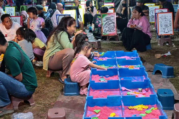 18 Haziran 2025 'te Lombok, Endonezya' da yaratıcı kum havuzu aktivitesine girişen küçük çocuk.