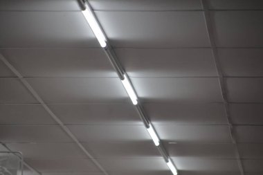 Floresan lambaları tavan ızgarasına yerleştirilmiş, aydınlatma ile ticari alanı geliştirilmiş ve çalışma ortamı için ortam atmosferi oluşturulmuştur.